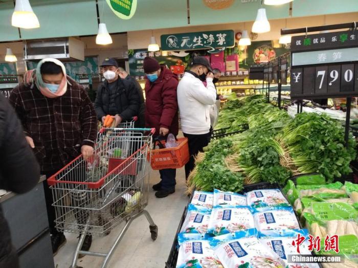 1月26日，农历大年初二，武汉超市内各种新鲜蔬菜供应充足，市民戴口罩选购。中新社记者 丁喆 摄
