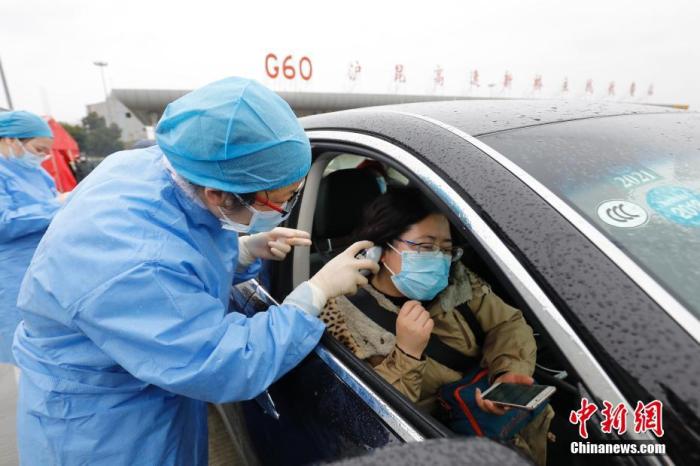 1月26日，大年初二，在G60沪昆高速新桥主线收费站，民警、辅警、医务人员严阵以待，对进入上海的车辆进行严格排查。针对新型冠状病毒感染的肺炎高发区域牌照的车辆进行全部检查，对其他区域牌照的车辆抽查，并对车内人员进行体温检测与信息登记。目前，医务工作者、公安干警与高速道口工作人员24小时驻守，共同筑起上海西南大门的首道防控网络。图为医护人员对乘客进行体温检测。殷立勤 摄