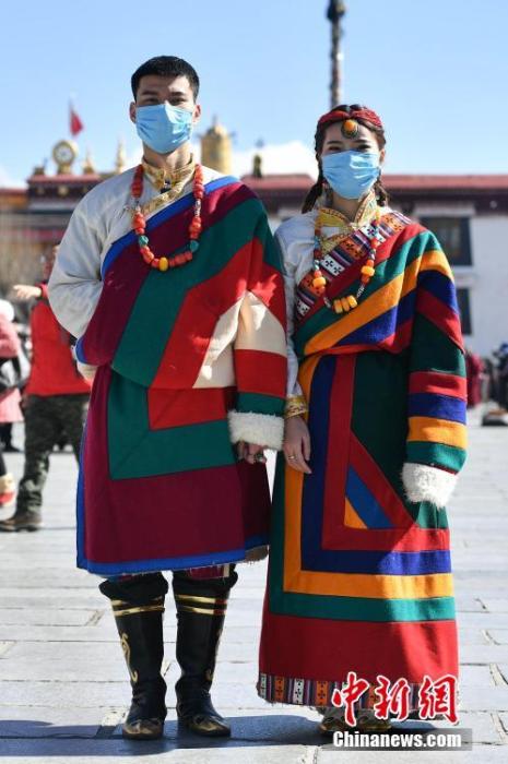 1月26日，大昭寺广场前拍摄结婚照片的一对新人戴上口罩。截至目前，新型冠状病毒感染的肺炎病例仍在上升，西藏自治区尚未发现疑似或确诊病例。面对疫情，拉萨民众齐心协力，全力预防新型冠状病毒。<a target='_blank' href='http://www.chinanews.com/'>中新社</a>发 钟欣 摄