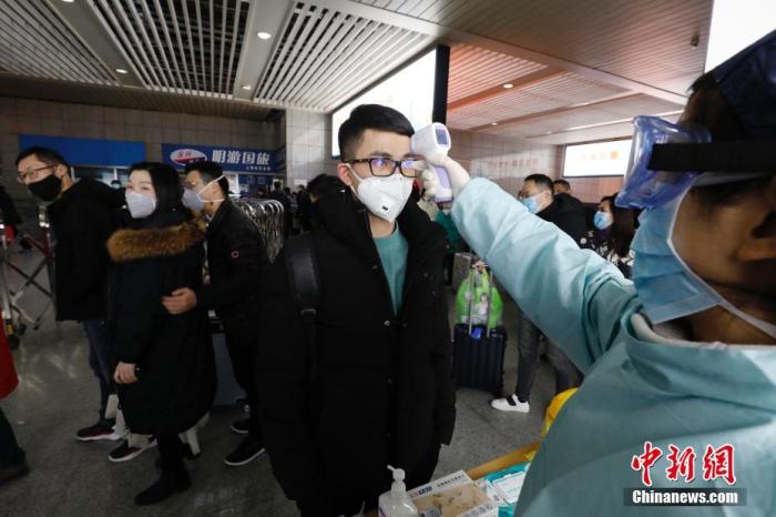 1月26日，旅客在上海站出站口接受体温检测。为防控新型冠状病毒感染的肺炎疫情，上海铁路方面采取了在上海、上海虹桥、上海南、上海西、安亭北、南翔北出站口设置测温点，对抵达上海的旅客全部进行体温检测。<a target='_blank' href='http://www.chinanews.com/'>中新社</a>记者 殷立勤 摄