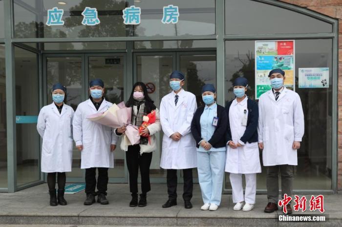 图为患者(左3)痊愈出院与救治医生合影。中新社记者 张亨伟 摄