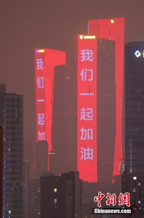 1月28日晚，南京闹市楼宇点亮“武汉加油”“我们一起加油”“戴好口罩”“勤洗手”等防疫标语字样。中新社记者 泱波 摄