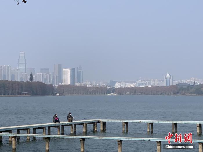 1月29日，武汉“封城”第七天，天气放晴，一些市民来到位于武汉大学凌波门外的东湖栈桥上，佩戴口罩垂钓。 <a target='_blank' href='http://www.chinanews.com/'>中新社</a>记者 杨程