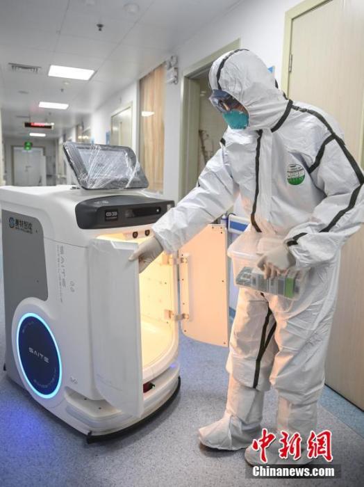 1月29日，工作人员将药品放入机器人“平平”的配送箱。当日，机器人“平平”和“安安”在广东省人民医院感染科病房启用。 中新社记者 陈骥旻 摄