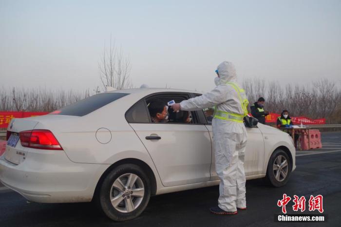 1月31日，为了防控新型冠状病毒感染的肺炎疫情，京沪高速武清西收费站对来津车辆和人员进行防疫检查。工作人员对车辆外表消毒，并对车上人员测量体温。中新社记者 贾天勇 摄