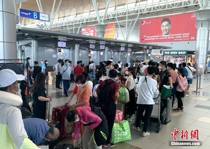 图为在马来西亚哥打基纳巴卢机场，滞留旅客正在排队办理手续。<a target='_blank' href='http://www.chinanews.com/'>中新社</a>发 廖志国 摄