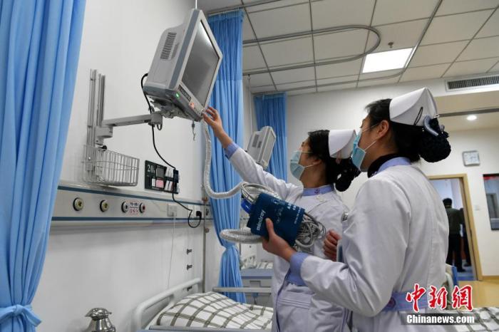 资料图：医护人员测试仪器。中新社记者 王东明 摄