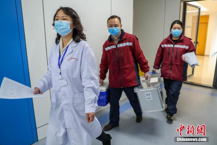 2月4日，武汉市疾控中心检测组工作人员进行病毒检测。武汉市疾控中心是该市首批获准开展新型冠状病毒核酸检测的机构之一。位于该中心病原生物检验所的生物安全二级实验室（P2实验室）则是“绝对禁区”。图为卫生防疫工作人员将送检标本拿进实验室。