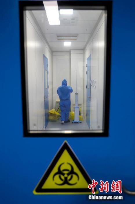 2月4日，武汉市疾控中心检测组工作人员进行病毒检测。武汉市疾控中心是该市首批获准开展新型冠状病毒核酸检测的机构之一。位于该中心病原生物检验所的生物安全二级实验室（P2实验室）则是“绝对禁区”。图为武汉市疾控中心的P2实验室的工作人员在换装。