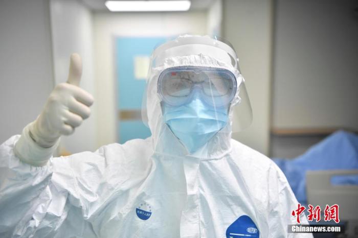 资料图：在云南省滇南中心医院(红河州第一人民医院)负压病房内的护士竖起大拇指。 中新社记者 刘冉阳 摄