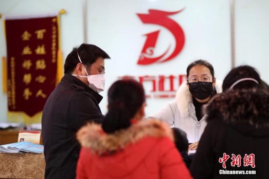 社区办事大厅，从外地返回南京的一家人正在进行申报。泱波 摄