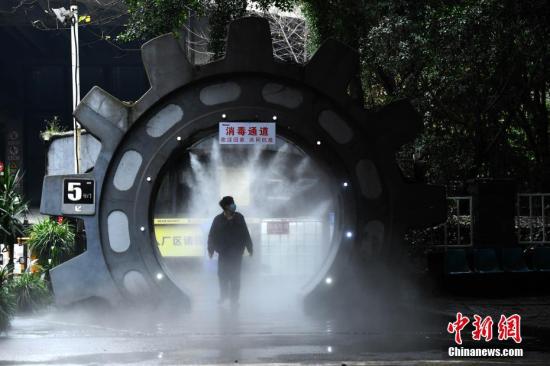 2月10日，为做好复工疫情防控工作，在位于重庆南岸区一企业大门处，企业安装了自动喷雾消毒装置，为进出企业的员工进行全身消毒杀菌。图为企业员工经过喷雾消毒处。<a target='_blank' href='http://www.chinanews.com/'>中新社</a>记者 陈超 摄