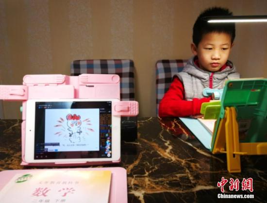2月10日，河北石家庄，小学生们正在家中通过电脑、平板电脑等收看直播上课。中新社记者 翟羽佳 摄