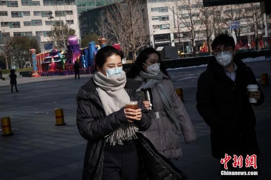 2月10日，北京民众佩戴口罩手持饮品出行。复工首日，北京金融街地区人流渐增。<a target='_blank' href='http://www.chinanews.com/'>中新社</a>记者 崔楠 摄