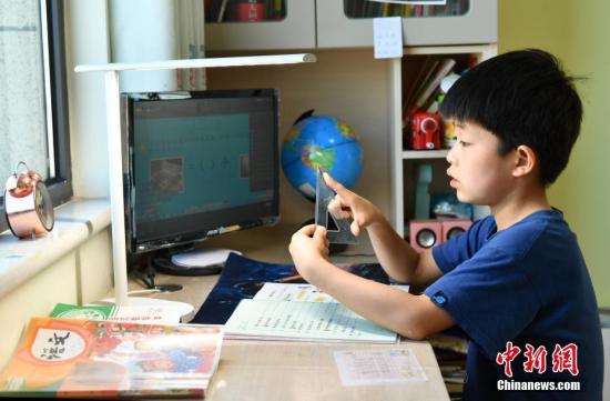 2月10日，河北石家庄，小学生们正在家中通过电脑、平板电脑等收看直播上课。<a target='_blank' href='http://www.chinanews.com/'>中新社</a>记者 翟羽佳 摄