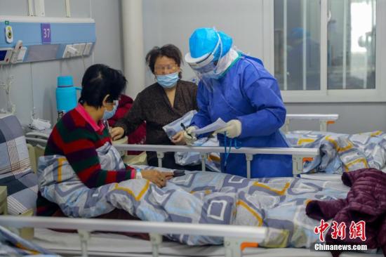 武漢火神山醫院感染二科一病區的隔離病房內護士長胡晶為患者進行身體檢查。<a target='_blank' href='http://www.itlfmzi.cn/'>中新社</a>記者 張暢 攝 武漢火神山醫院感染二科一病區的隔離病房內護士長胡晶為患者進行身體檢查。<a target='_blank' href='http://www.itlfmzi.cn/'>中新社</a>記者 張暢 攝