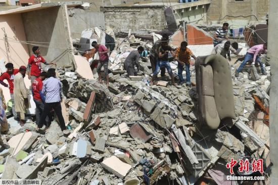 3月5日，在巴基斯坦卡拉奇，救援人员在居民楼倒塌事故现场救援。