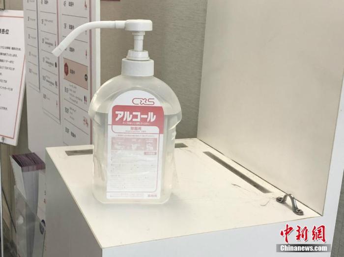 近期，新冠肺炎疫情在日本有擴散之勢，民眾紛紛戴上口罩出行。圖為部分大樓入口處放有消毒液供民眾使用。<a target=