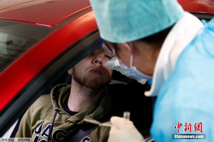 当地时间3月11日，比利时列日地区中心医院新型冠状病毒检测点，一名护士对坐在车内的患者采集鼻拭子。