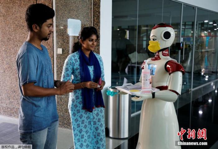 当地时间3月17日，印度一家公司研发的机器人手持一个装有口罩和洗手液的托盘。这两个机器人是为了向人们介绍新冠病毒而推出的。