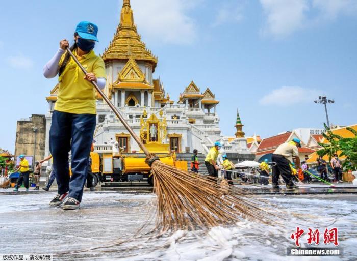 当地时间3月18日，泰国曼谷金佛寺进行大扫除，志愿者使用消毒剂清洁清理地面。