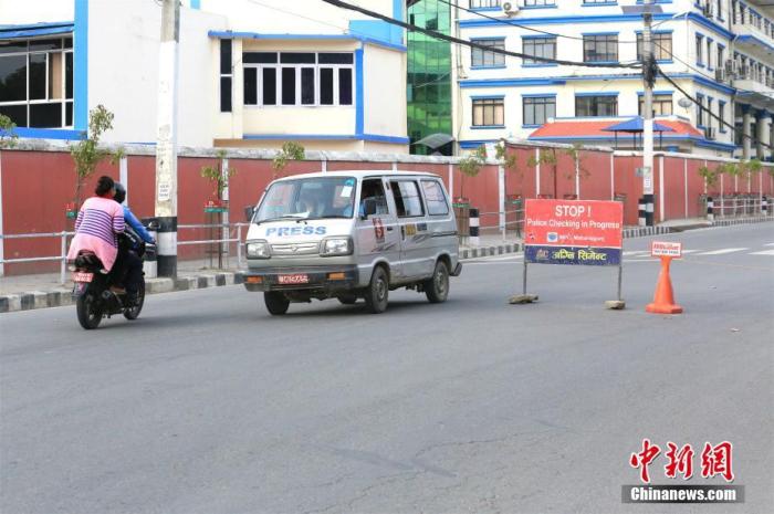 3月27日，加德满都，一辆汽车及摩托车行驶在尼泊尔总统府附近。当天是尼泊尔实行全国性封锁的第四天，市民在室外开展有限的活动。
<a target='_blank' href='http://www.chinanews.com/'>中新社</a>记者 张晨翼 摄