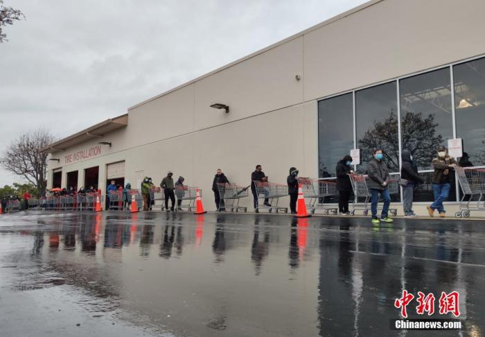当地时间3月28日，美国旧金山湾区民众在位于福斯特城的Costco超市外冒雨排起长队，等候购买物资。<a target='_blank' href='http://www.chinanews.com/'>中新社</a>记者 刘关关 摄