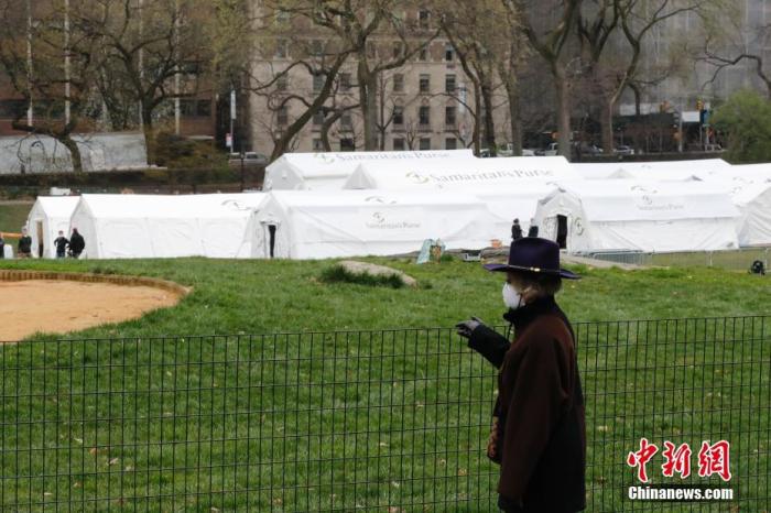 当地时间3月30日，美国纽约中央公园内正在搭建临时医院，一位民众凭栏眺望。<a target='_blank' href='http://www.chinanews.com/'>中新社</a>记者 廖攀 摄