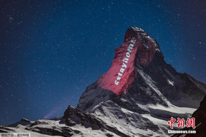 当地时间4月1日，瑞士阿尔卑斯山脉标志性的马特洪峰出现灯光投影的巨大横幅，在疫情中呼吁“希望和团结”。图为马特洪峰山顶出现的“待在家里”灯光投影。
