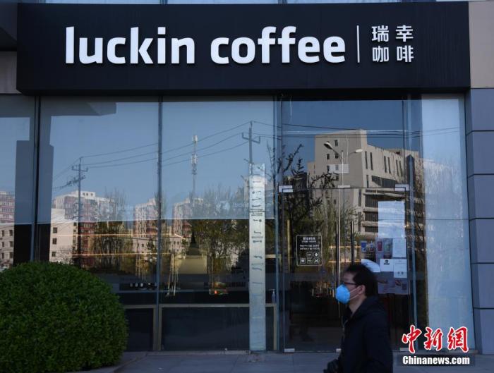 资料图：一名行人经过瑞幸咖啡北京宝能大厦店前。中新社记者 侯宇 摄