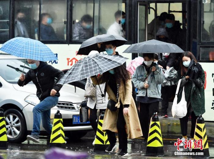 资料图：市民冒雨出行。中新社记者 翟羽佳 摄