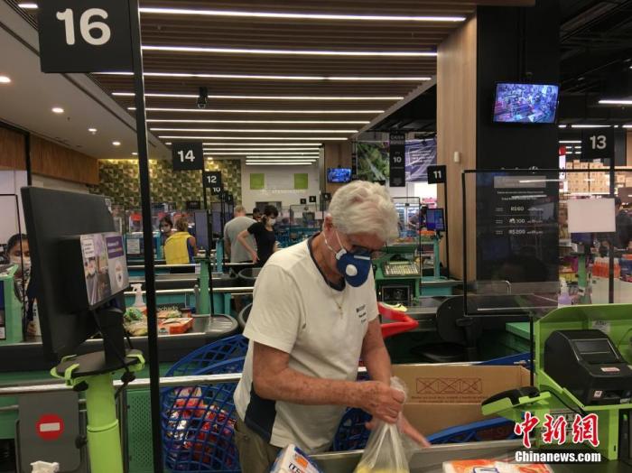 当地时间4月9日，在巴西圣保罗，一名男子戴着口罩在一家超市购物。