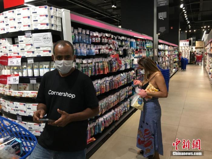 当地时间4月9日，在巴西圣保罗，民众戴着口罩在一家超市购物。