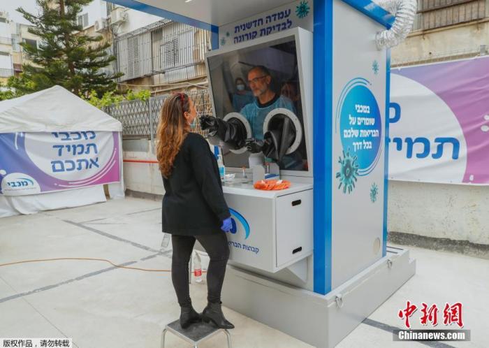当地时间4月16日，以色列Maccabi医疗服务公司在沿海城市特拉维夫安装了一个新型冠状病毒测试台，医务人员可以从民众身上采集拭子样本。图为一名女士在接受拭子样本采集。