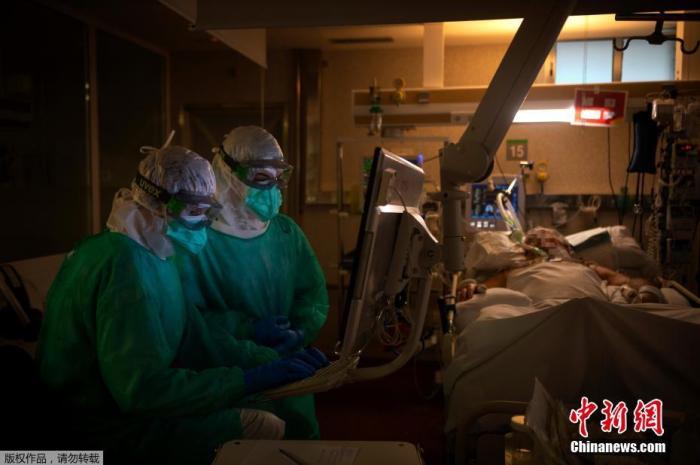 当地时间4月16日，在西班牙西北部维戈的Povisa医院重症监护室，医护人员在看护一名新型冠状病毒患者时检查监视器。