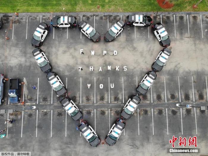 近日，美国迈尔斯堡警察在一所医院大楼前用警车拼成“爱心”形状致谢医护人员。