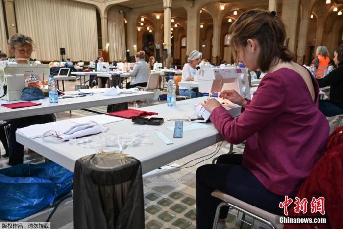 4月23日，志愿者在法国里尔市政厅改造的临时厂房内制作口罩。 法国里尔市政厅从本周开始成为了临时口罩生产车间，多名志愿者在此制造口罩。