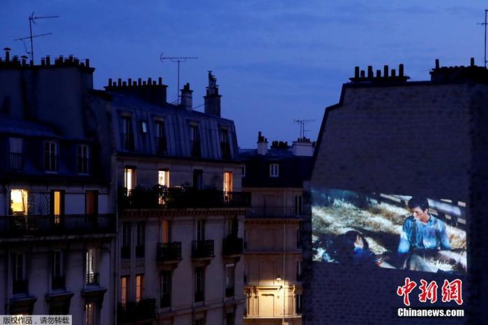 当地时间4月24日，法国巴黎，一家庭影院协会成员在公寓墙壁上放映电影。