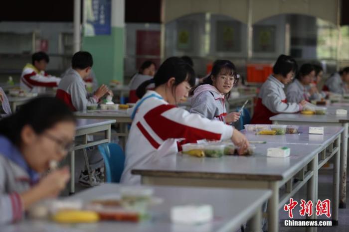 资料图：学校食堂内，学生保持一定的距离就餐。中新社记者 蒋启明 摄