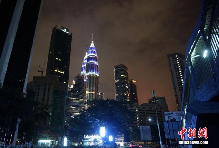 4月30夜，应马来西亚政府呼吁，吉隆坡等联邦直辖区多栋地标建筑亮蓝灯致敬抗疫前线医护人员。图为吉隆坡著名地标双子塔在夜空中闪烁蓝色灯光。<a target='_blank' href='http://www.chinanews.com/'>中新社</a>记者 陈悦摄