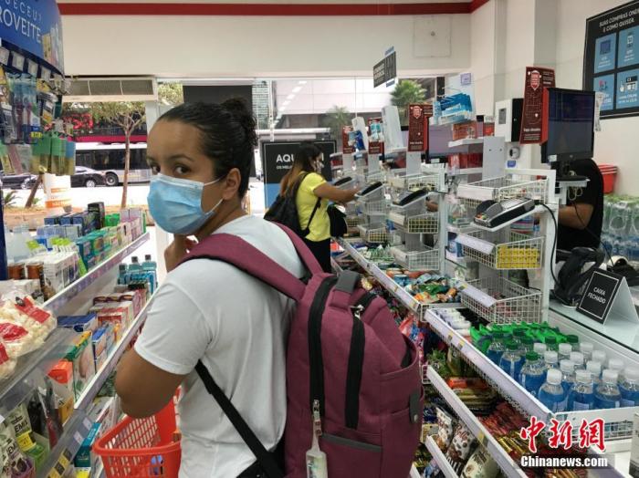 当地时间5月1日，在巴西圣保罗，一位戴口罩的妇女在一家药店购买药品。在“五一”国际劳动节这一天，巴西最大城市圣保罗仍处于因疫情实施的“社会隔离”期，街上商店紧闭，行人稀少。<a target='_blank' href='http://www.chinanews.com/'>中新社</a>记者 莫成雄 摄