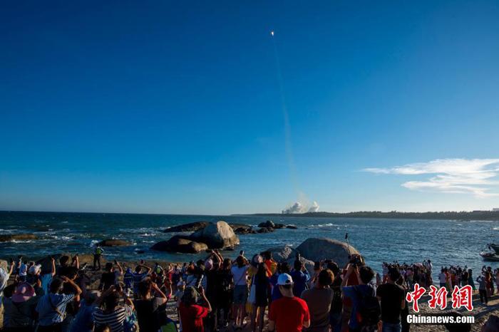 图为民众在海边观看长征五号B运载火箭点火升空。 骆云飞 摄