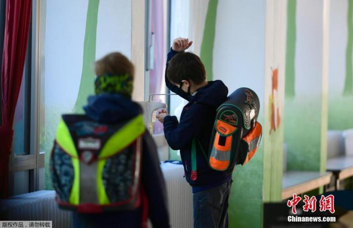 当地时间5月7日，德国西部，多特蒙德的Petri小学学生开学复课，一名学生进入教室后进行手部清洁。