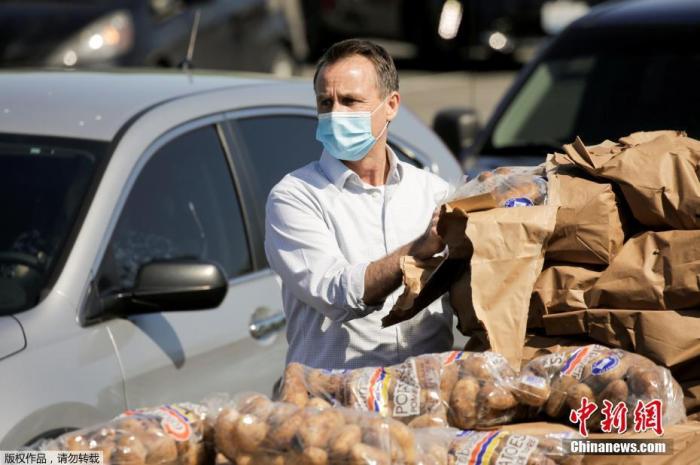 当地时间5月7日，美国华盛顿马铃薯委员会在奥本市组织了一项活动，志愿者们将装袋的土豆发放给民众。这些土豆因受疫情影响，供应链堵塞而面临滞销。