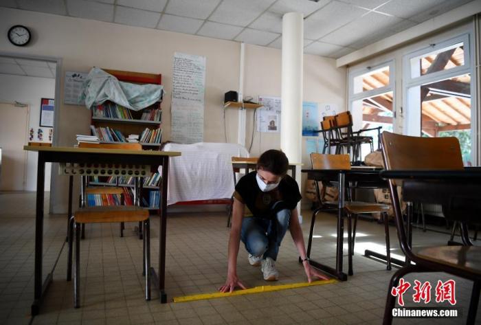 当地时间5月7日，法国克莱尔芬塔恩伊夫林的一间学校内，校长德尔芬贝迪奥在教室内贴社交距离标识。