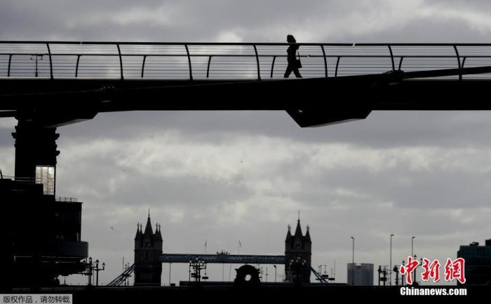 当地时间5月11日，英国伦敦，行人步行穿过泰晤士河上的千年桥。据报道，当地时间10日，英国首相鲍里斯·约翰逊宣布一项“有条件的计划”，逐步放松因新冠肺炎疫情采取的严格封锁措施，开始重新开放社会和经济。