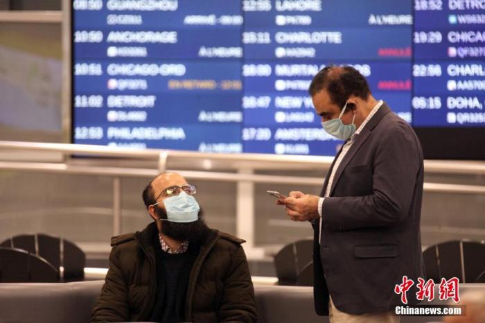 两位戴口罩的旅客在冷清的加拿大多伦多皮尔逊国际机场休息。<a target='_blank' href='http://www.chinanews.com/'>中新社</a>记者 余瑞冬 摄