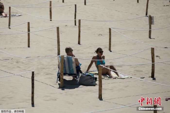 当地时间5月24日，在法国南部的拉格兰德莫特，在海滩上晒日光浴的人们躺在一个标志明显的区域内，以执行社交隔离措施。