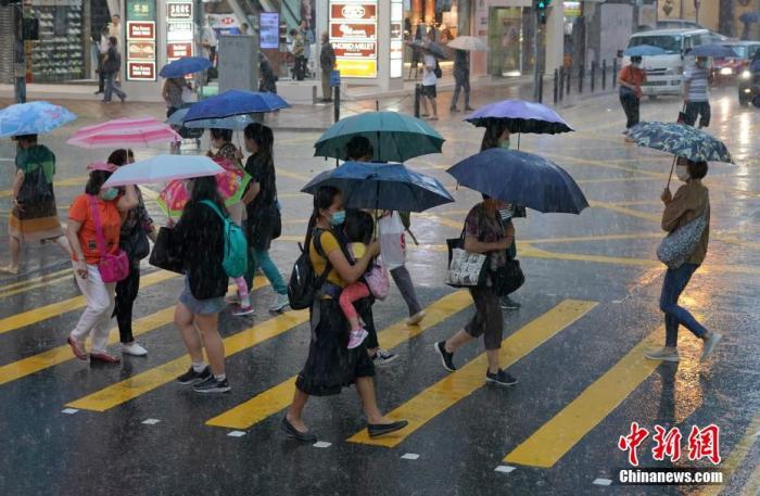 资料图：市民在街头撑伞出行。<a target='_blank' href='http://www.chinanews.com/'>中新社</a>记者 张炜 摄