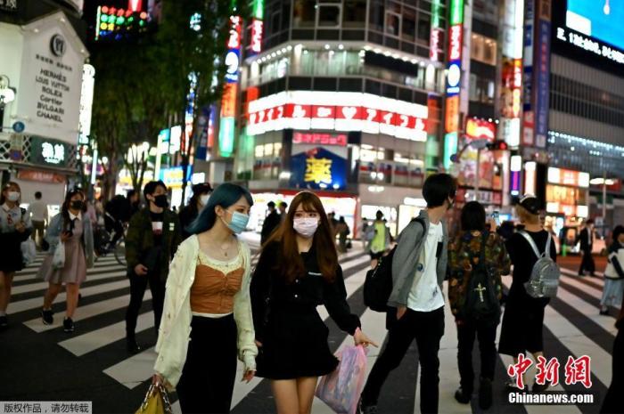 当地时间5月25日，东京新宿区，戴口罩的人们穿过街道。